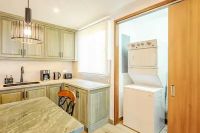 a kitchen with a white refrigerator and a table at Luxury Oceanview Penthouse, Breathtaking Sunsets in Tamarindo