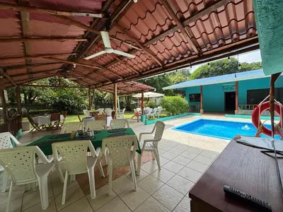 a patio with a table and chairs and a pool at Camping Finca Planeta Sano in Naranjito