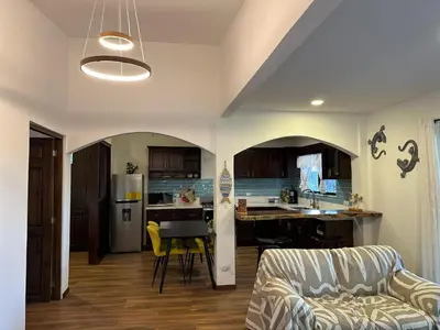 a living room with a couch and a kitchen at La Chozita in Tamarindo