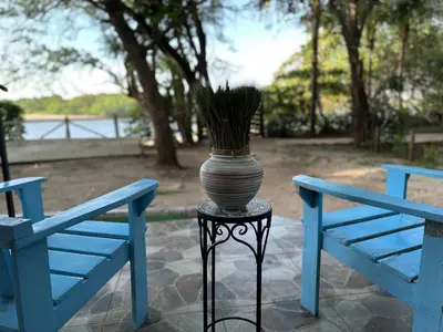 a vase sitting on a stand next to two blue benches at La Chozita in Tamarindo