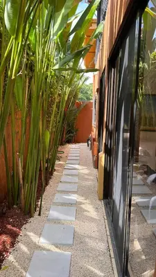 a garden path with plants next to a building at La Flor beach Condos in Jacó