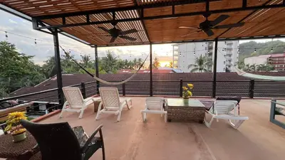 a patio with chairs and a table and a hammock at La Flor beach Condos in Jacó