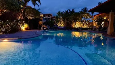 a large swimming pool at night at La Flor beach Condos in Jacó