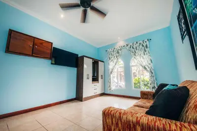 a living room with a couch and a ceiling fan at Villa Atardecer by Vacation Pura Vida in Bejuco