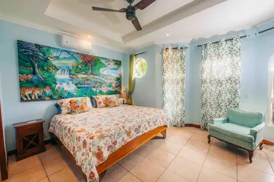 a bedroom with a bed and a painting on the wall at Villa Atardecer by Vacation Pura Vida in Bejuco