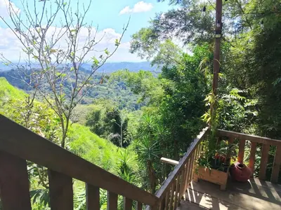 a wooden deck with a view of the mountains at Somos Zapatón Catarata EL REY in Zapatón
