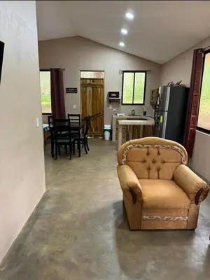a living room with a couch and a kitchen at New casita walking distance to Avellanas beach in Río Sequito