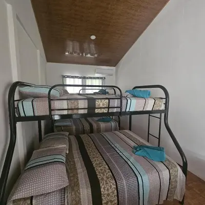 three bunk beds in a small room with at Cabaña y Piscina el Lorito in Uvita