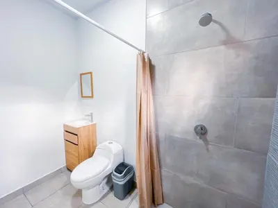 a bathroom with a shower and a white toilet at Forest apartments studio F3, walking to the beach! in Jacó