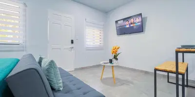 a living room with a blue couch and a tv at Forest apartments studio F3, walking to the beach! in Jacó