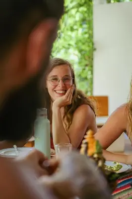 a girl sitting at a table smiling at a table at Awake Uvita in Uvita