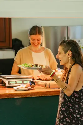 a woman giving a woman a plate of food at Awake Uvita in Uvita