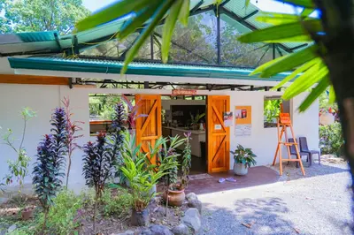 a building with orange doors and plants in front at Awake Uvita in Uvita