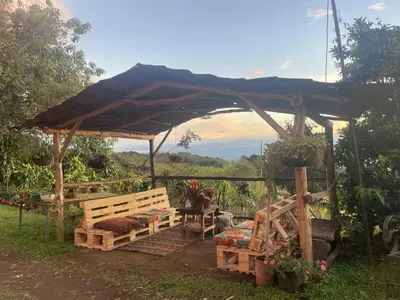 a wooden gazebo with a bench and a table at Mountain Chalet with Valley View in Alajuela City
