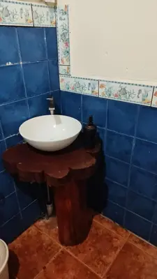 a bathroom with a white sink on a wooden table at Mountain Chalet with Valley View in Alajuela City
