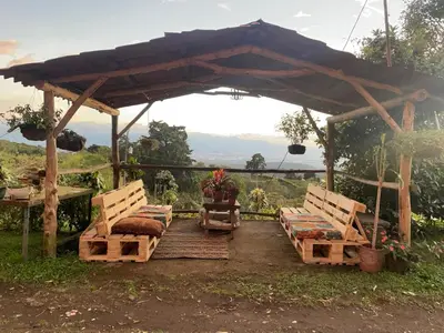 a gazebo with two beds and a table and chairs at Mountain Chalet with Valley View in Alajuela City