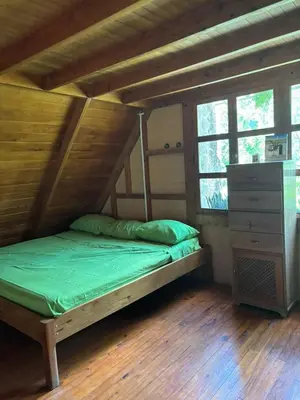 a bed in a room with a wooden floor at Mountain Chalet with Valley View in Alajuela City