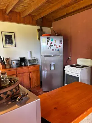 a kitchen with a stainless steel refrigerator and a stove at Mountain Chalet with Valley View in Alajuela City