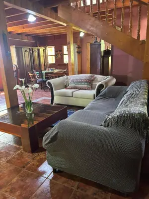 a living room with a couch and a table at Mountain Chalet with Valley View in Alajuela City