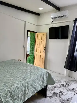 a bedroom with a bed and a television and a door at Mini Casa Aura in Fortuna