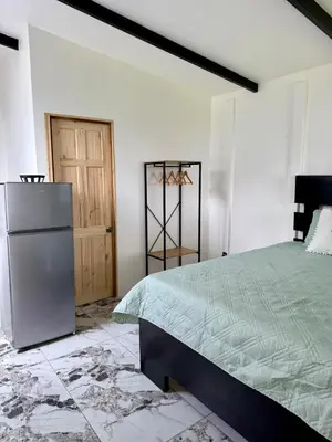 a white bedroom with a bed and a door at Mini Casa Aura in Fortuna