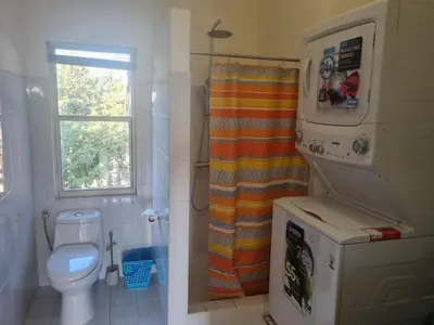 a bathroom with a toilet and a shower curtain at Beach Front Condo for 10 people in Tamarindo