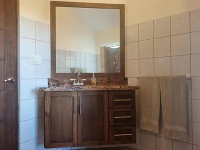 a bathroom with a sink and a mirror at Beach Front Condo for 10 people in Tamarindo