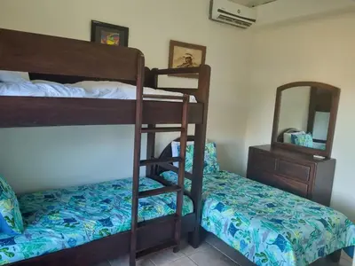 a bedroom with two bunk beds and a mirror at Beach Front Condo for 10 people in Tamarindo