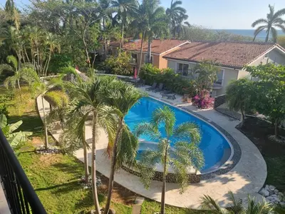 an image of a swimming pool in front of a house at Beach Front Condo for 10 people in Tamarindo