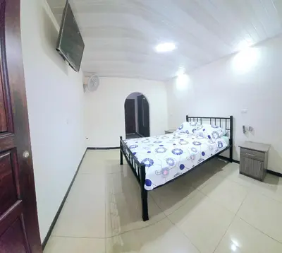 a bedroom with a bed and a tv on a wall at Apartamentos Cabo Verde B1 in Uruca