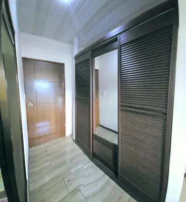 a walk in closet with wooden doors in a room at Apartamentos Cabo Verde B1 in Uruca