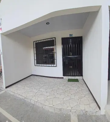 a white building with a door and a window at Apartamentos Cabo Verde B1 in Uruca