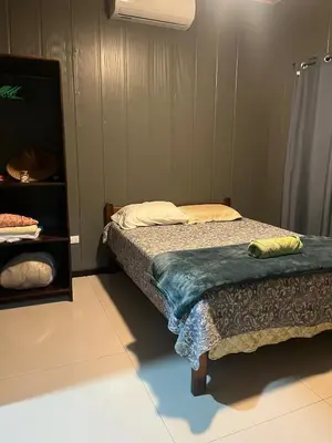 a bedroom with a bed and a night stand at Casa Briana in Uvita
