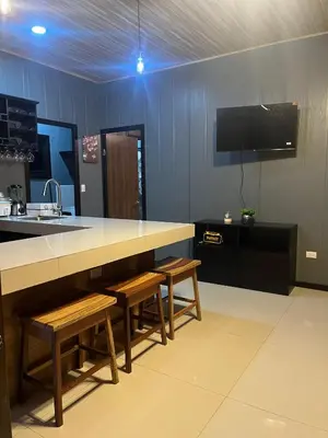 a kitchen with a counter and benches and a sink at Casa Briana in Uvita