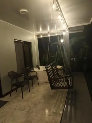 a porch with a swing with a bed in the background at Paradise Experience Costa Rica in Pueblo Nuevo