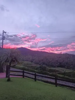 a sunset over a hill with a fence and a tree at Paradise Experience Costa Rica in Pueblo Nuevo