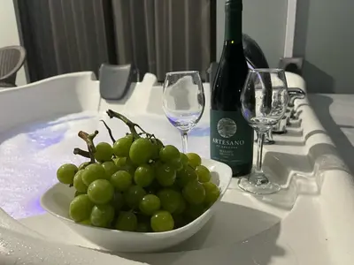 a white bowl of grapes on a table with wine glasses at Paradise Experience Costa Rica in Pueblo Nuevo