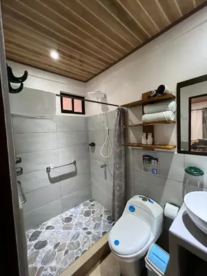 a bathroom with a toilet and a sink at Apartamentos Mansión Tropical in Quepos