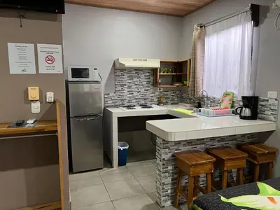 a kitchen with a sink and a stove top oven at Apartamentos Mansión Tropical in Quepos