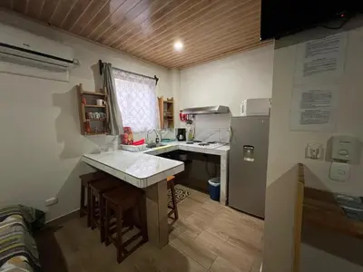 a small kitchen with a sink and a refrigerator at Apartamentos Mansión Tropical in Quepos