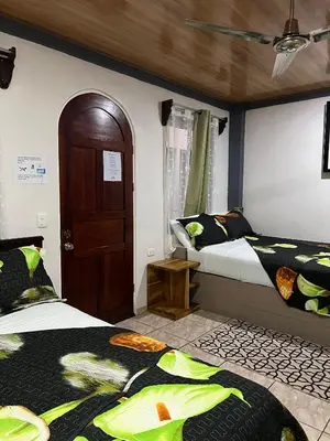 a bedroom with two beds and a ceiling at Apartamentos Mansión Tropical in Quepos
