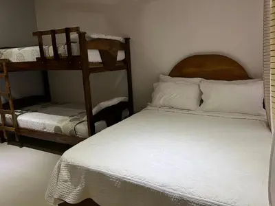 a bedroom with a bed and a bunk bed at Apartamentos Mansión Tropical in Quepos
