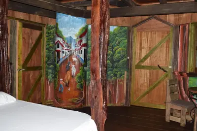 a bedroom with a painting on the wall at Mirador Prendas in Sarapiquí