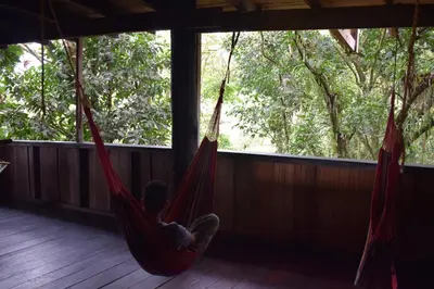 a child in a hammock in a room with a window at Mirador Prendas in Sarapiquí