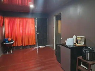 a room with red curtains and a room with a table at Casa Lilly in Pejibaye