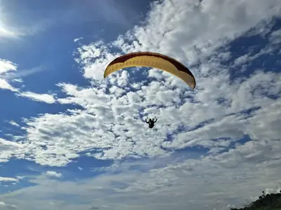 a person flying a parachute in a cloudy sky at Casa Lilly in Pejibaye