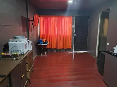 a kitchen with a microwave and a red curtain at Casa Lilly in Pejibaye