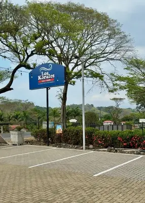 a sign in a parking lot with a tennis court at Punta Leona, beach 5mn,gated parking, AC, TV, WiFi in Quebrada Ganado