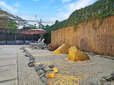 a patio with a bench and an umbrella and a fence at Luxury Villa with rooftop infinity pool and walk away from the beach in Jacó