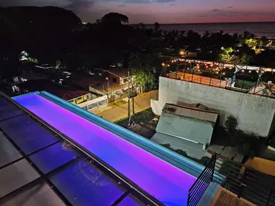 a swimming pool on the roof of a house at night at Luxury Villa with rooftop infinity pool and walk away from the beach in Jacó